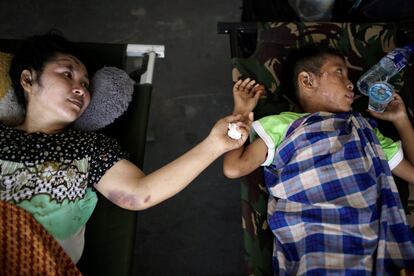 Una madre y su hijo, ambos heridos, esperan para ser evacuados en un avión militar en Indonesia.  