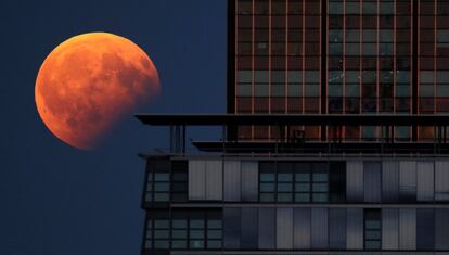 Vista do eclipse lunar parcial depois de um edifício em Berlim (Alemanha).