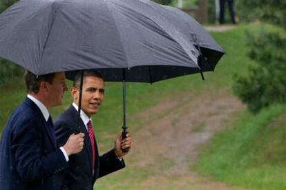 David Cameron y Barack Obama caminan bajo la lluvia a su llegada a la cumbre del G-20, en Toronto.