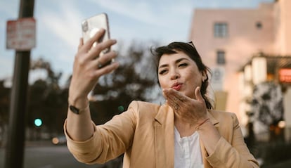 Uso de WhatsApp  en un móvil con una chica despidiéndose