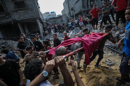 Varios hombres transportan a dos hermanas palestinas tras ser encontradas entre los escombros de una casa destruida tras un ataque aéreo, en el campo de refugiados de Al Shatea, este martes en Gaza.