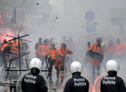 Los estibadores de Amberes han lanzado indiscriminadamente petardos y empujado a la gente, además de agredir a un fotógrafo e intentar en varias ocasiones romper el cerco policial. En la imagen, algunos manifestantes lanzan piedras a la policía durante la protesta, 4 de abril de 2014.