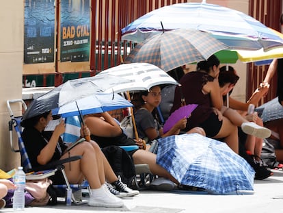 Varias personas se refugian del calor bajo paraguas, el jueves en Murcia.