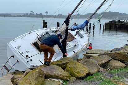 Dos hombres atienden un velero que rompió el ancla en Porto Bodega y terminó en las rocas durante una tormenta en Bodega Bay, el pasado 5 de enero.
