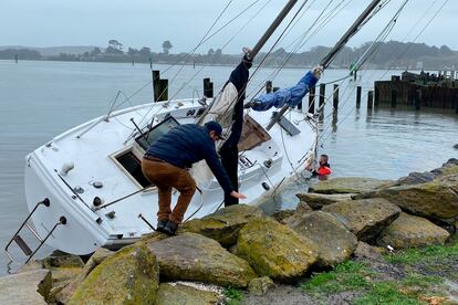 Dos hombres atienden un velero que rompió el ancla en Porto Bodega y terminó en las rocas durante una tormenta en Bodega Bay, el pasado 5 de enero.