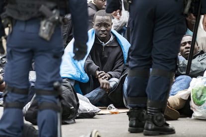 Un migrante espera a ser desalojado por la policía durante el desmantelamiento de un campamento temporal de inmigrantes, en la avenida Flandre en el norte de París (Francia).
