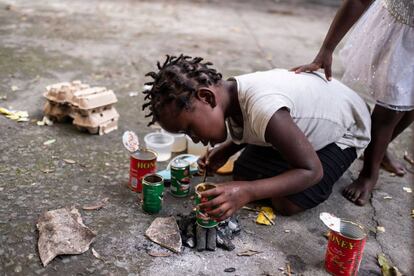 Una niña intenta calentar comida en la Samora Machel High School de Beira, Mozambique, el 23 de marzo, donde se alojan damnificados desplazados de la zona de Buzi, muy afectada.