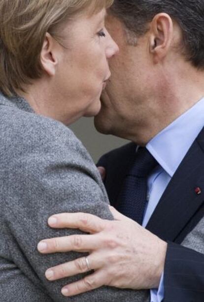 Merkel saluda a Sarkozy a su llegada hoy al El Elíseo.
