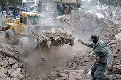 Un hombre guía a una excavadora que retira escombros de una de las viviendas destruidas por el terremoto en la ciudad de Bam.