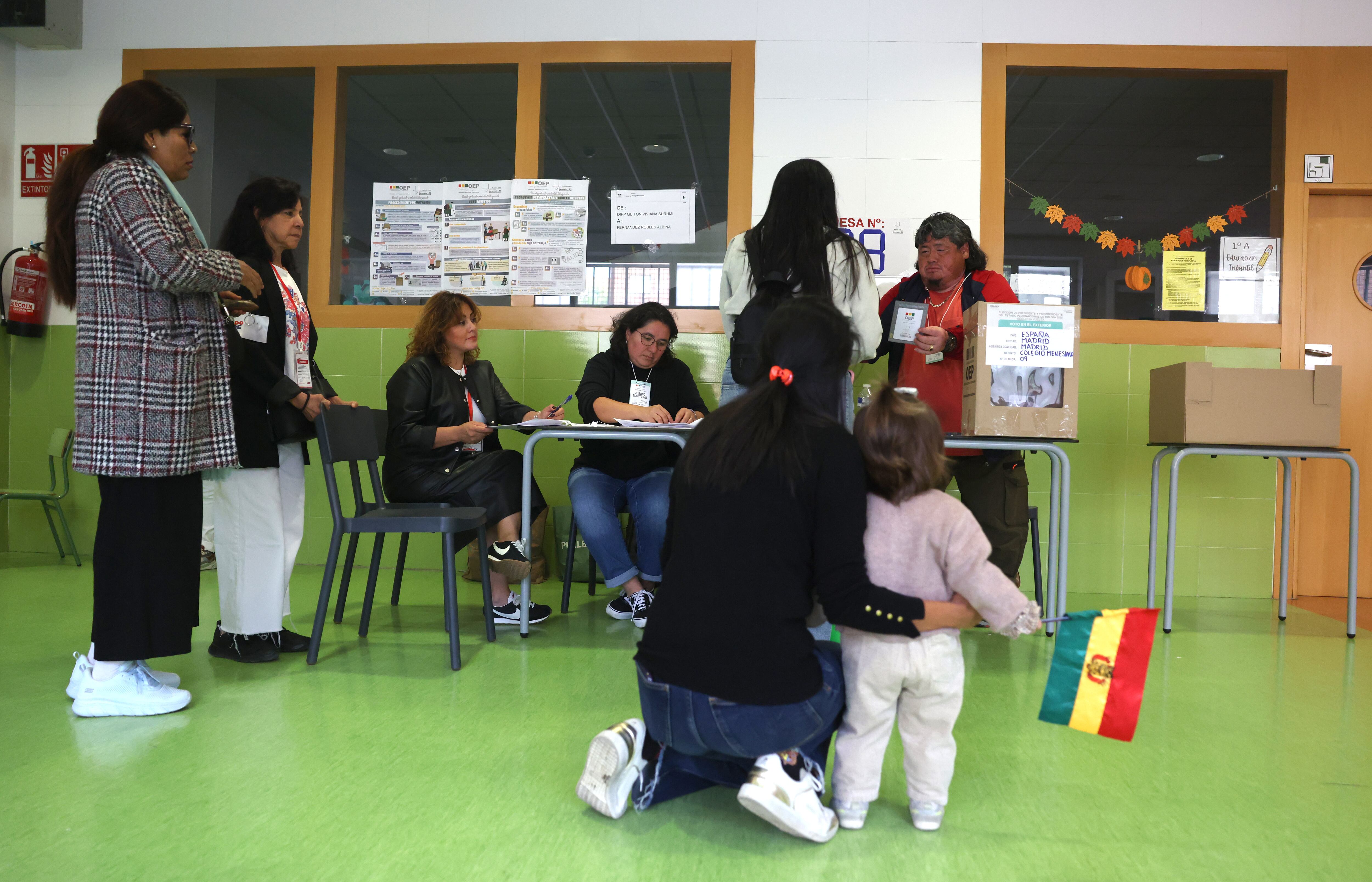 Una mujer boliviana y su hija en un centro de votación en Madrid, este domingo.