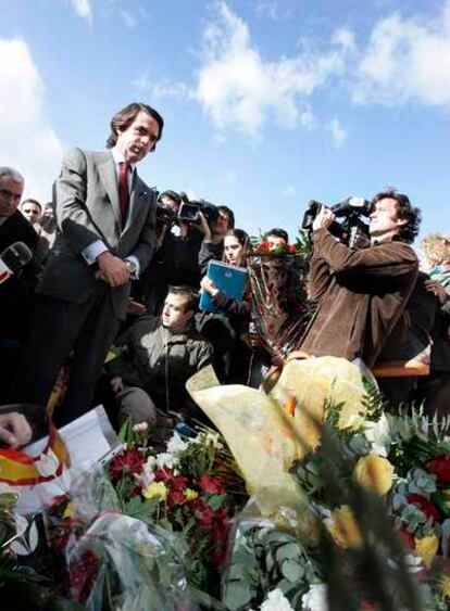 El ex presidente del Gobierno José María Aznar, rodeado de periodistas y reporteros gráficos tras depositar un ramo de rosas en la plaza de la República Dominicana en Madrid.