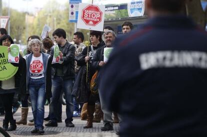 Un 'ertzaina' vigila la concentración de Stop Desahucios en San Sebastián.