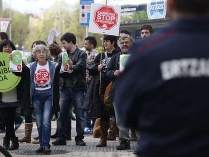 Un 'ertzaina' vigila la concentración de Stop Desahucios en San Sebastián.