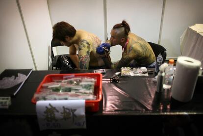 Un tatuador pinta la piel de uno de los asistentes al encuentro celebrado en Taiwan.