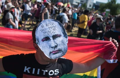 Un manifestante lleva una máscara con la cara del presidente Putin, en la que se puede leer "En Rusia esta máscara sería ilegal".