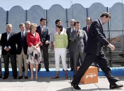 Mariano Rajoy pasa delante de los barones regionales del Partido Popular tras la foto de familia.