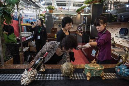 Algunos de los asistentes a la feria prueban los distintos accesorios de cocina que los empresarios han llevado a la capital del país asiático.