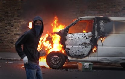 Un joven participa en los disturbios acaecidos en el verano de 2011 en Londres.