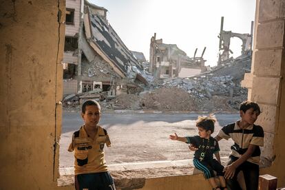     ----PIEFOTO----    Tres niños entre los edificios destruidos por la guerra. 