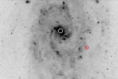 Imagen, tomada con el Hubble, de la galaxia (centro marcado con un círculo blanco), de la que posiblemente se está escapando un agujero negro (marcado en rojo).