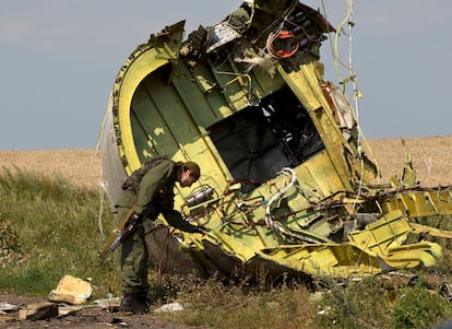 Un uniformado inspeccionaba los restos del MH17 tras su derribo en el este de Ucrania, en julio de 2014.