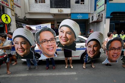 Un grupo de personas sostiene cartulinas recortadas con las caras de diferentes candidatos al Senadoen Caloocan City, al norte de Manila (Filipinas). La campaña electoral para los comicios municipales y legislativos del próximo 13 de mayo ha arrancado este martes.