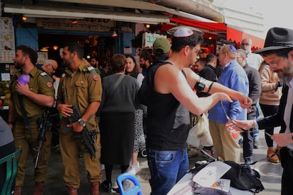Militares pasan delante de un ultraortodoxo en una calle de Jerusalén