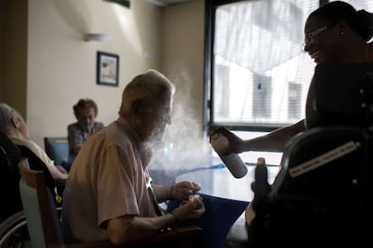 Una enfermera refresca con agua pulverizada a un anciano en una residencia para mayores en Lyon (Francia).