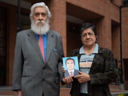 Padres de Eduardo Calderón, sosteniendo una foto de su hijo, en el norte de Bogotá, el pasado 29 de marzo.