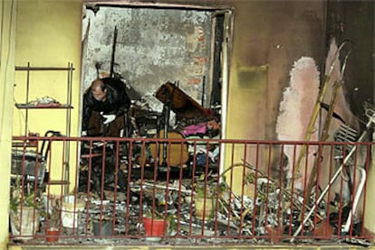 Un policía examina la vivienda de la calle Pablo Picasso tras el pavoroso incendio.