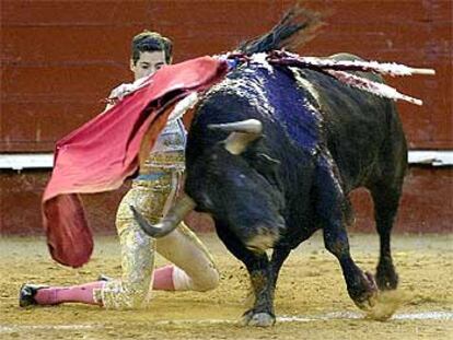 César Jiménez, de rodillas, inicia la faena al sexto de la tarde.