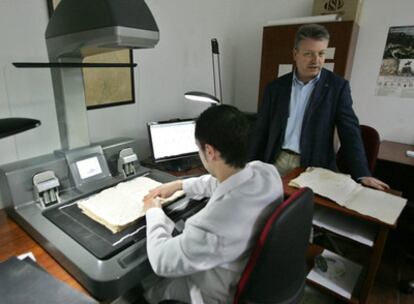 Primo Jurado, de pie, ayer en el Palacio de Viana junto a un trabajador que digitaliza un legajo.