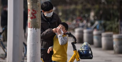 Una madre ayuda a limpiarse la cara a un niño en Wuhan. 