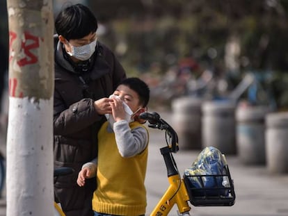 Una madre ayuda a limpiarse la cara a un niño en Wuhan. 