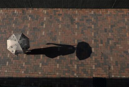 Una mujer camina bajo el sol en Hong Kong.