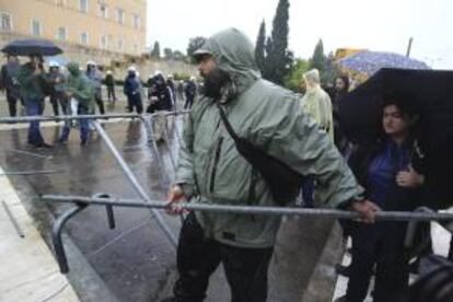 Un manifestante trata de echar abajo una de valla de seguridad durante una protesta frente al Parlamento Griego, en Atenas. EFE/Archivo