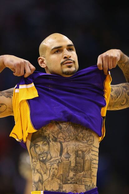 Robert Sacre, de los Lakers, se levanta la camiseta durante el partido ante San Antonio