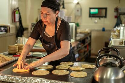 Una cocinera coloca tortillas de harina en la plancha.