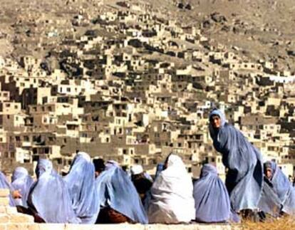 Un grupo de mujeres afganas, ataviadas con el <b></b><i>burka</i>, espera la distribución de ayuda humanitaria en Kabul.