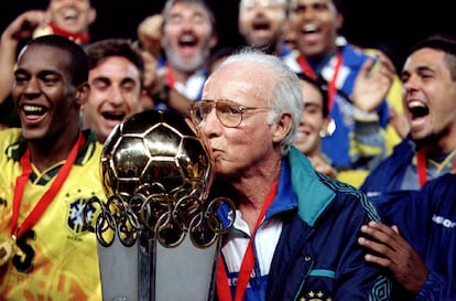 Brazil's coach Mario Zagallo kisses the cup of the South American Olympic soccer championship, surrounded by his team.
