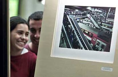 Una pareja tras la fotografía <i>Todo es </i><i>movimiento,</i> de Carlos Jaime Bertrán Expósito, una de las expuestas en Bilbao.