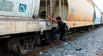 Un migrante sube a un tren en marcha en México en 2013.