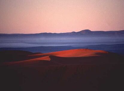 Amanecer en las dunas de Merzouga, al sur de Marruecos; al fondo, la cordillera del Atlas.