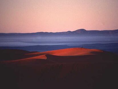 Amanecer en las dunas de Merzouga, al sur de Marruecos; al fondo, la cordillera del Atlas.