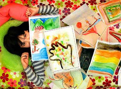 Silvana muestra orgullosa sus pinturas en la habitación de su casa.