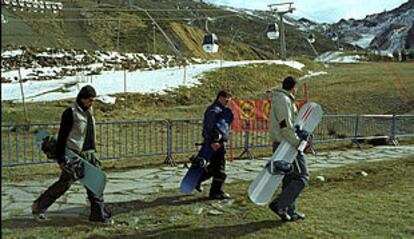 Tres jóvenes con tablas de <i>snowboard,</i> en las inmediaciones de la pista del Río, ayer, en Sierra Nevada.