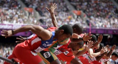 Los atletas a punto de comenzar la carrera de 100 metros.