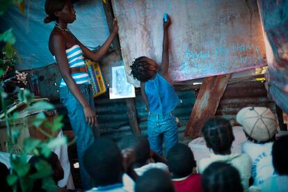 Una niña escribe en la pizarra de una escuela improvisada por un habitante local en medio de un campo de refugiados de Port-au-Prince. 23 de septiembre de 2010.