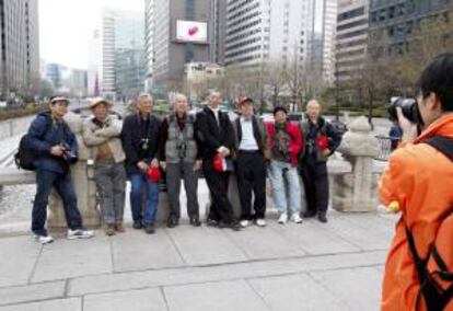 Turistas extranjeros posan para las fotos en una calle principal de Seúl, Corea del Sur. EFE/Archivo
