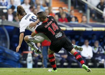 Bustos, del Celta, intenta detener a Modric en el Bernab&eacute;u.